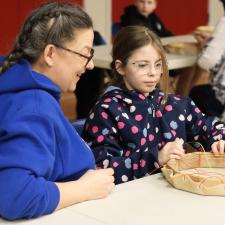 Indigenous Support Worker supporting student with drum making